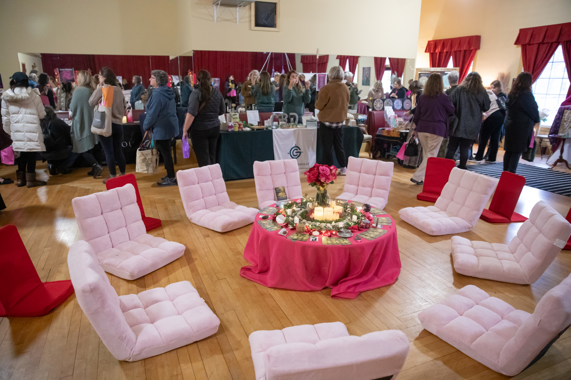 Pink floor chairs arranged in a circle around a candlelit altar table