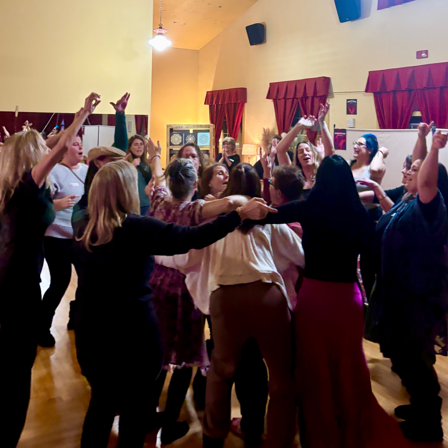 Women dancing together with arms raised at the closing dance party
